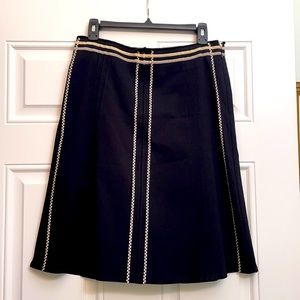 Anthropologie black A-line skirt With white trim and side zipper.